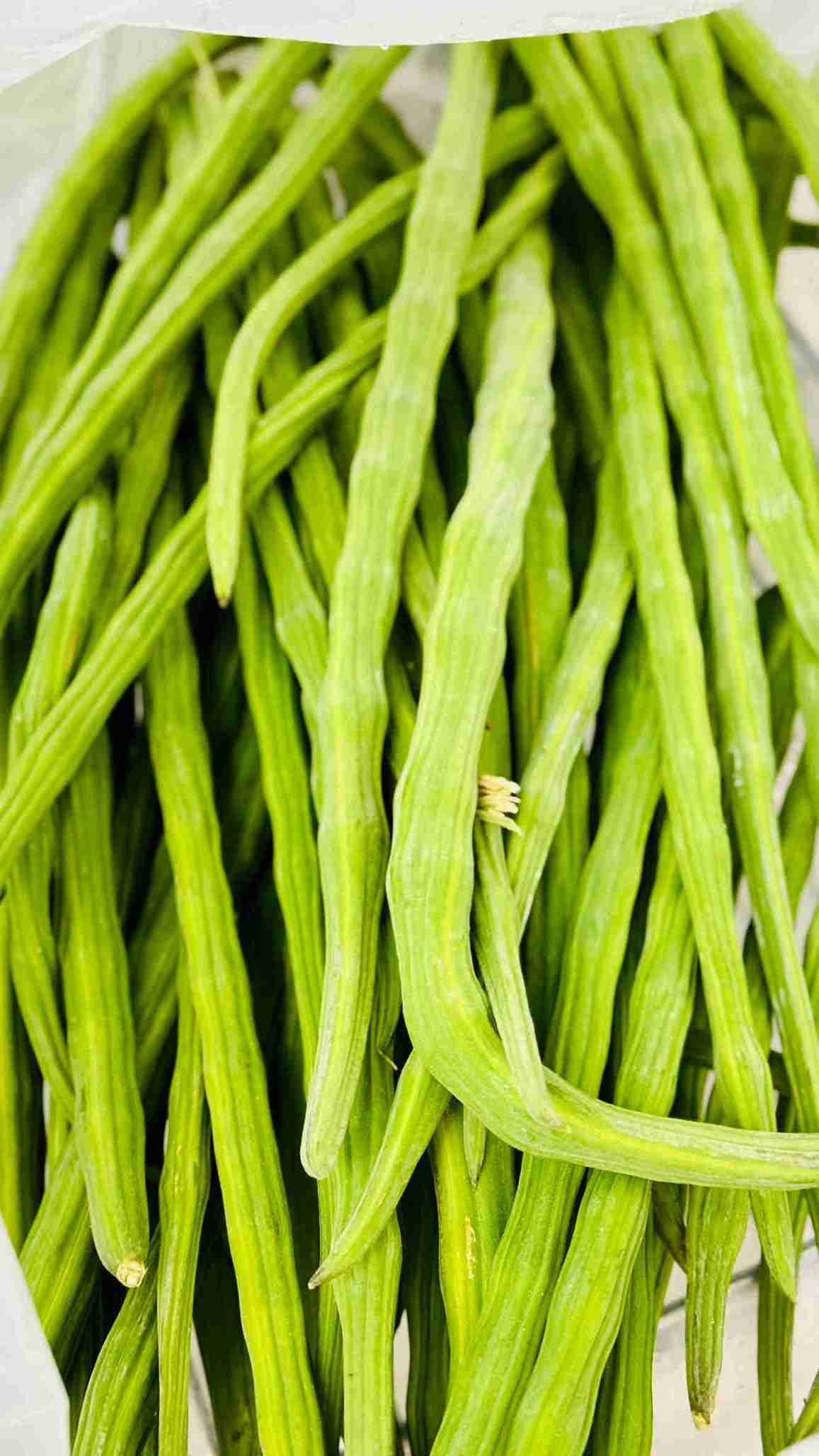 Bundles of fresh green drumsticks, known as Sajne Danta, on display at Bismillah Grocery & Meat Market.