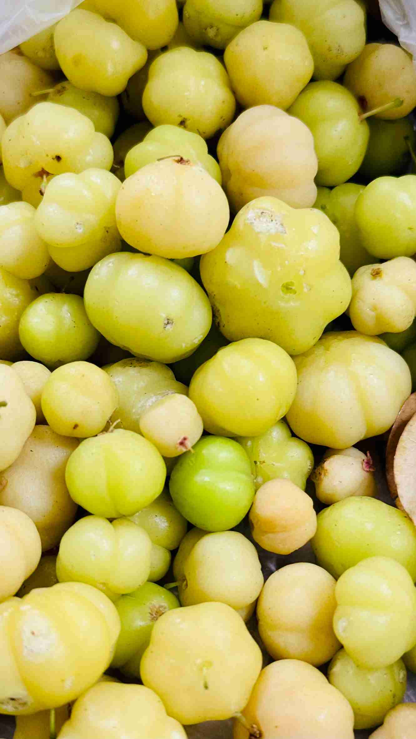 A pile of fresh, pale yellow star gooseberries, known as Orboroi, on display at Bismillah Grocery & Meat Market.