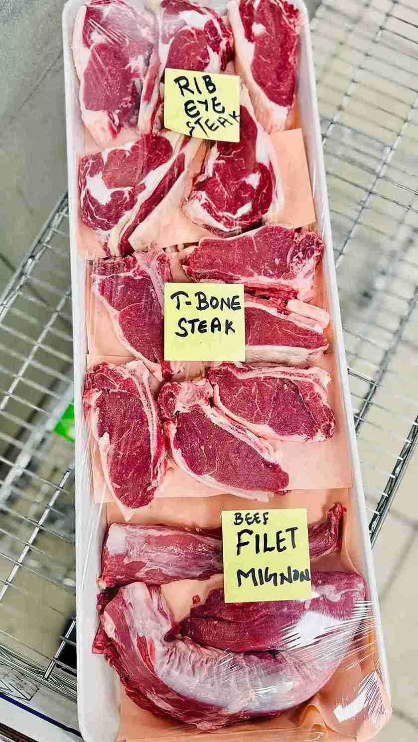 Premium cuts of fresh beef on a tray, including Rib Eye Steak, T-Bone Steak, and Beef Fillet Mignon, available at Bismillah Grocery & Meat Market.