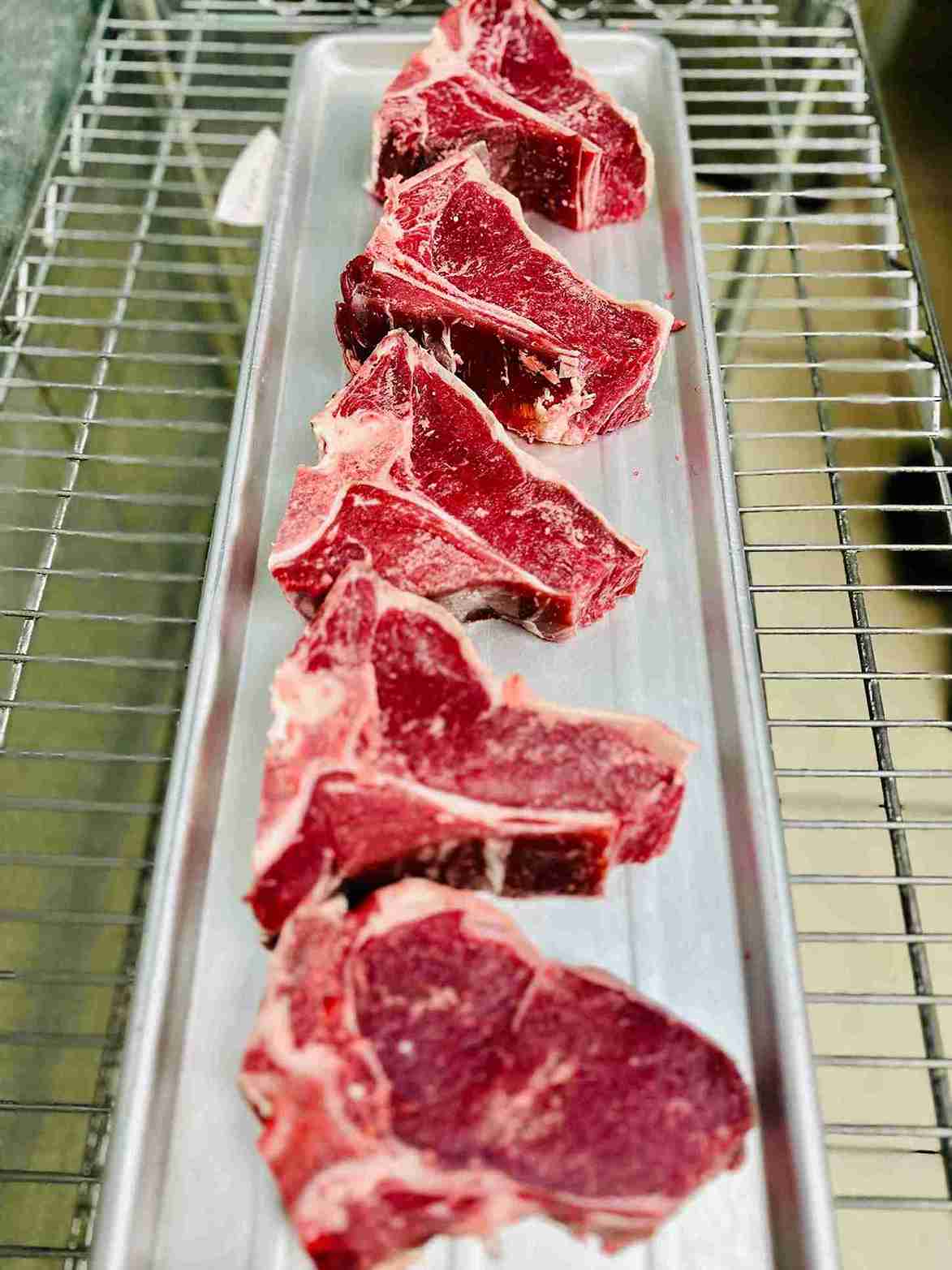 Premium cuts of Beef T-Bone and Ribeye steaks on display at Bismillah Grocery & Meat Market.